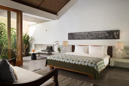a bedroom with a bed and a living room at Atelier TE Designer Guesthouse in Sanur