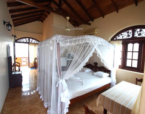 En eller flere senge i et værelse på Hotel Dhammika