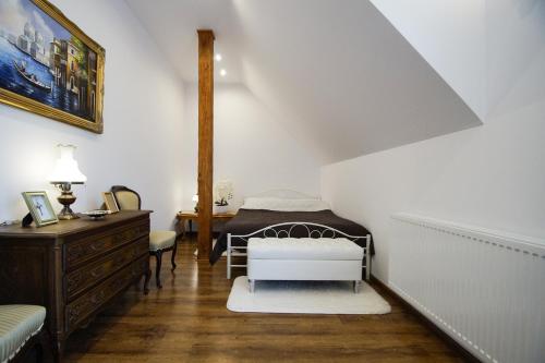 um quarto com uma cama e uma cómoda num sótão em Villa Nad Jeziorem em Kruklanki