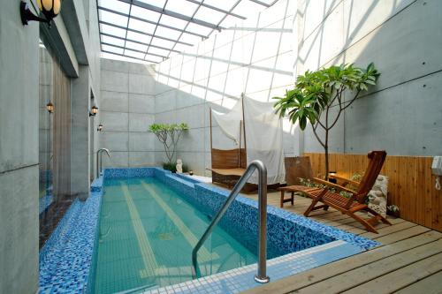 a swimming pool in a building with a glass ceiling at Zhen 13 Villa Motel in Yongkang