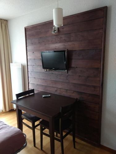 a room with a table and a tv on a wall at VVF Val-Cenis Haute-Maurienne in Lanslevillard