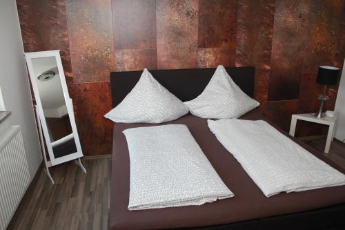 a bedroom with a bed with two pillows and a mirror at Gästehaus Chaplin in Kempten