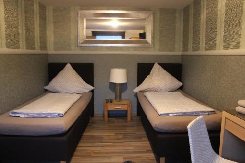 two beds in a room with a mirror at Gästehaus Chaplin in Kempten