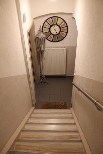 a stairway with a clock on the wall and a clock at Gästehaus Chaplin in Kempten