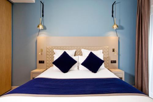 een slaapkamer met een blauw en wit bed met twee blauwe kussens bij Residhome Bordeaux in Bordeaux