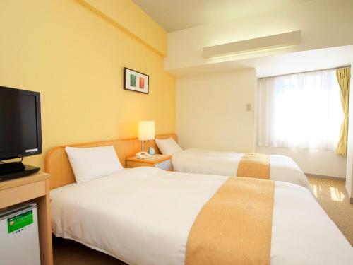 מיטה או מיטות בחדר ב-Chisun Inn Nagoya