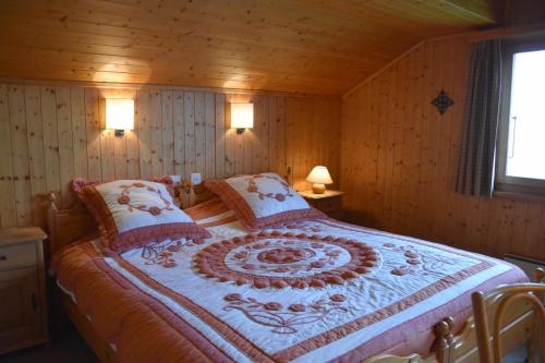 ein Schlafzimmer mit einem Bett in einem Holzzimmer in der Unterkunft Val Dieu in Verbier