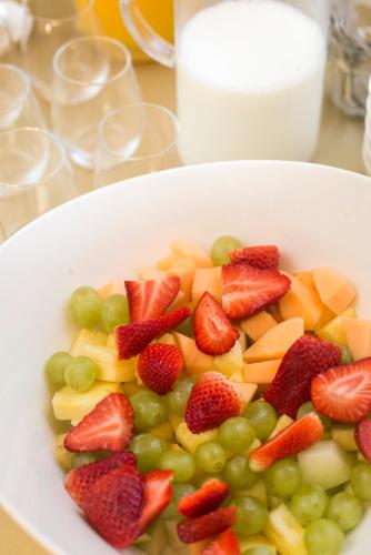 a white bowl of fruit with strawberries and grapes at Hotel - Restaurant De 4 Jaargetijden in Epen