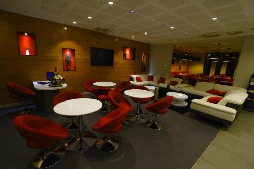 a restaurant with red chairs and tables in a room at Tulip Inn Sainte Clotilde, La Réunion in Saint-Denis