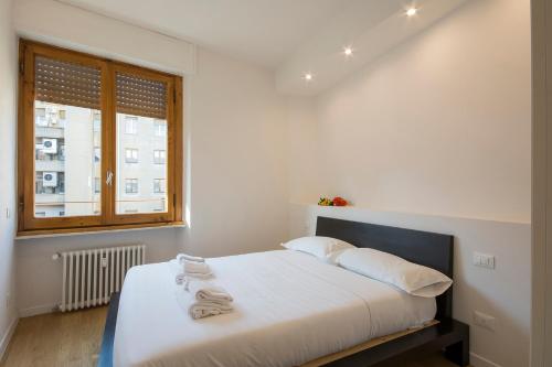 1 dormitorio con 1 cama con sábanas blancas y ventana en Alinari Apartment, en Florencia