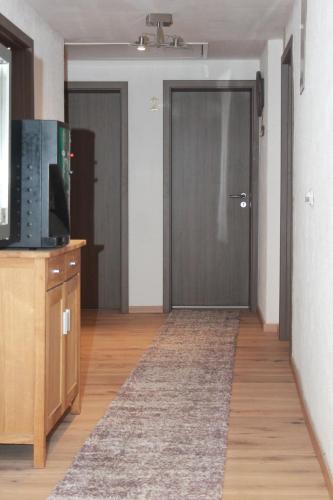 a living room with a door and a television at Gästehaus Chaplin in Kempten