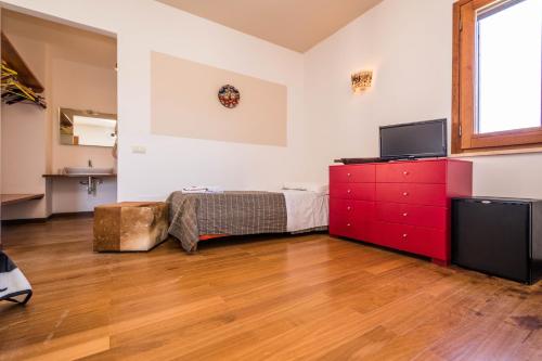 a bedroom with a bed and a red dresser at B&B Le Dune - Self Check in in Lascari