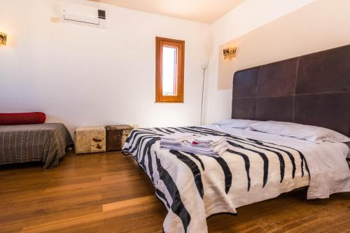 a bedroom with a large bed with a black headboard at B&B Le Dune - Self Check in in Lascari