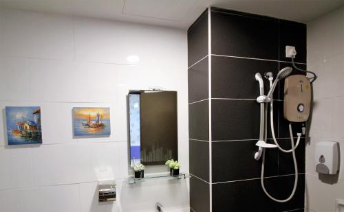 uma casa de banho com um chuveiro e um espelho. em H2H - Marine Home @ Majestic Ipoh (8~10 Guests) em Ipoh