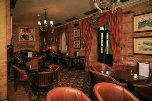 a bar with tables and chairs in a restaurant at Garrison Hotel in Sheffield
