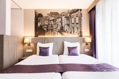 two beds in a hotel room with a picture on the wall at Best Western City Hotel Woerden in Woerden