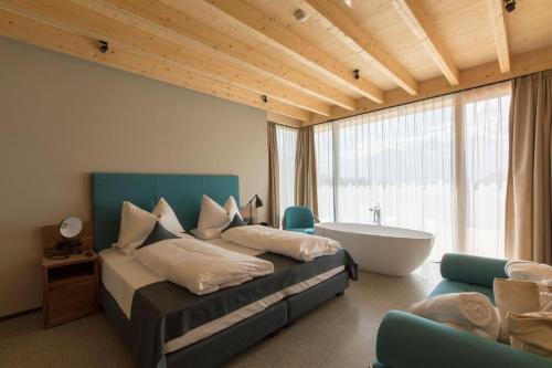 1 dormitorio con 1 cama y bañera en una habitación en Hotel Garberhof, en Malles Venosta