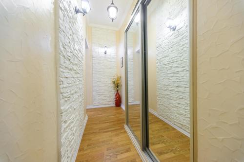 a hallway with white brick walls and a mirror at Kiev Centre Apartments in Kyiv