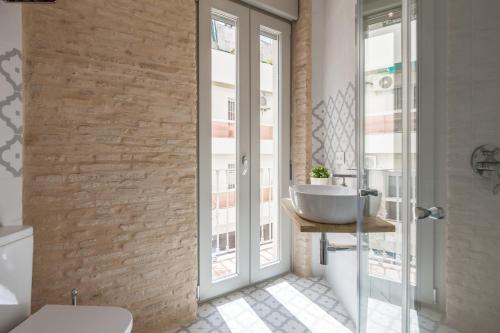 La salle de bains est pourvue d'un lavabo et de toilettes. dans l'établissement Apartamentos RG Suites Jardines de Murillo, à Séville