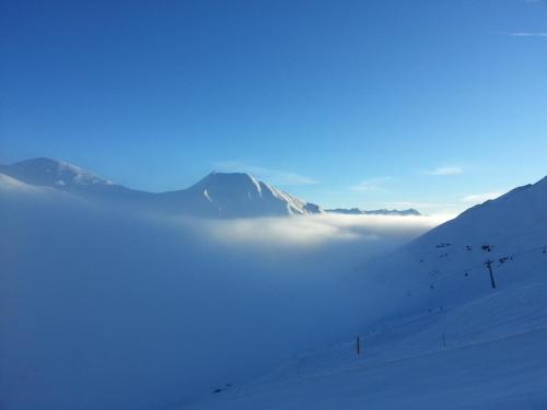 a view of a snow covered mountain with a layer of clouds at Haus Derby in Samnaun