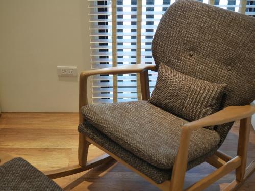 a chair sitting in a room with a window at See Moon Homestay in Yuchi