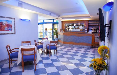 un restaurante con mesa y sillas y un bar en Hotel Smeraldo, en Tortoreto Lido