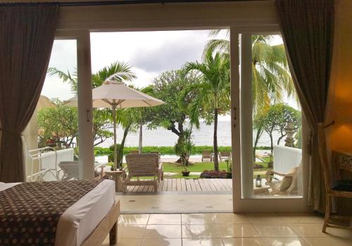 a bedroom with a bed and a view of the ocean at Tauch Terminal Resort Tulamben & Spa in Tulamben