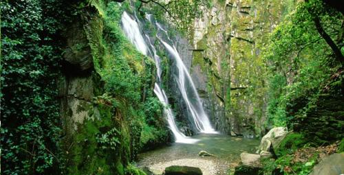 a waterfall on the side of a mountain with a river at Casa da Alta in Coja
