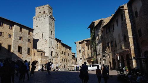 a group of people walking down a street with a tower at Agriturismo Villino del Grillo in San Gimignano