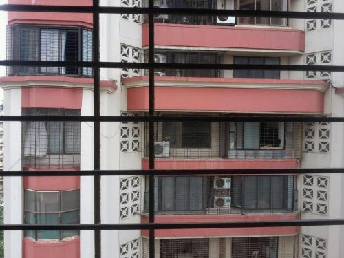 an apartment building seen through a window at Pinaki Comfort Stay in Mumbai