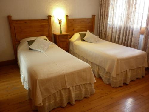 two beds in a room with wooden floors at 816 B&B in Mendoza