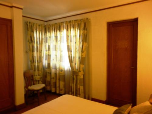 a bedroom with a bed and a window with curtains at 816 B&B in Mendoza