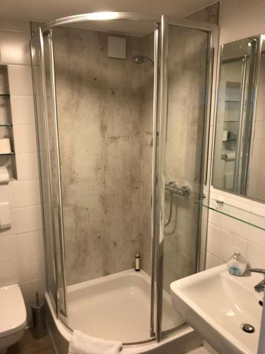 ein Badezimmer mit einer Dusche, einem Waschbecken und einer Badewanne in der Unterkunft Apartment Yoursylt One in Westerland