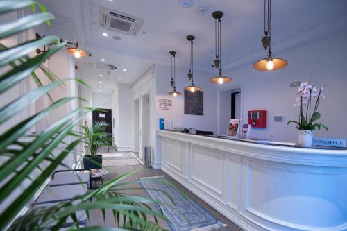 um bar numa sala com vasos de plantas e luzes em Hotel Majestic em Budva