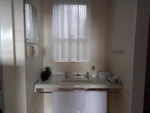 a bathroom with a sink and a window and towels at Redwood Lodge Motel in Levin