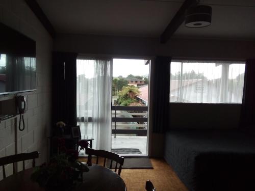 a living room with a view of a balcony at Redwood Lodge Motel in Levin