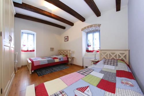a bedroom with two beds and two windows at Olive's Hug in Poljana