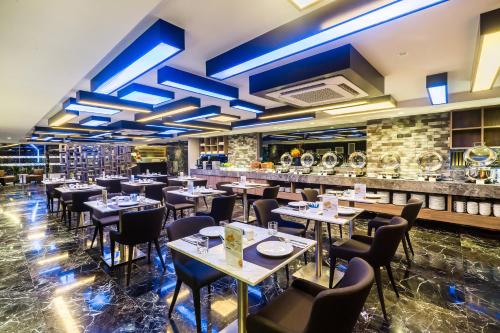 バンコクにあるCitrus Suites Sukhumvit 6 by Compass Hospitalityのテーブルと椅子とバーのあるレストラン