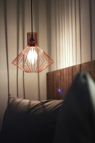 a bedroom with a bed with a light and a lamp at Novitel Hotel Kirchheim - München Messe in Kirchheim