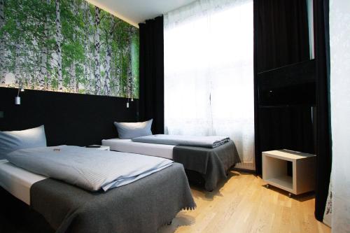 a bedroom with two beds and a painting on the wall at Novitel Hotel Kirchheim - München Messe in Kirchheim