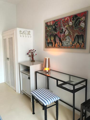 a room with a desk and a chair and a painting at Oklacà Patmos Beach Rooms in Patmos