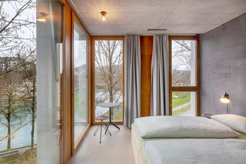 a bedroom with a bed and a large window at Bern Youth Hostel in Bern