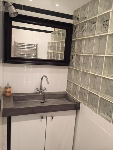 une salle de bain avec un lavabo et un miroir dans l'établissement appartement Breil sur Roya centre, à Breil-sur-Roya