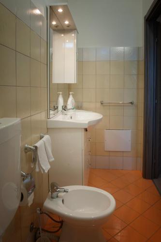 a bathroom with a sink and a toilet and a mirror at Asaro Camere in Campobello di Licata