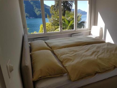 CastagnolaにあるVilla Violetta - Miralagoの大きな窓付きの客室のベッド1台分です。