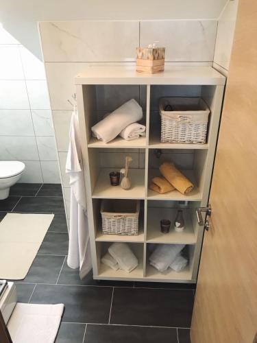 a shelf in a bathroom with towels and baskets at SiMa in Baška Voda