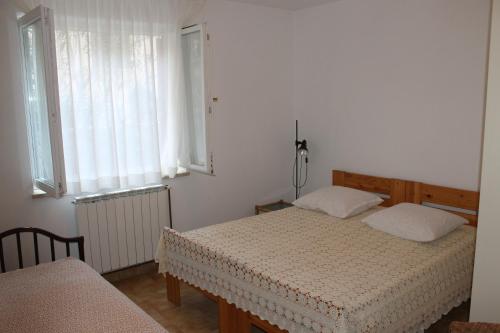 a bedroom with two beds and two windows at Apartments Vila Marica in Rabac