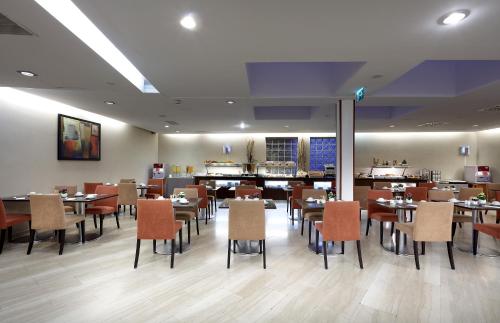 a dining room with tables and chairs in a restaurant at Exe Vienna in Vienna