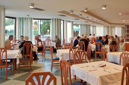 a group of people sitting at tables in a restaurant at TRH Jardín Del Mar in Santa Ponsa