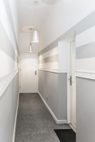 a hallway with white walls and a white door at Classic Apartments - Top Location, bezpłatny parking in Ełk